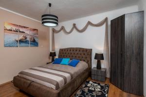 a bedroom with a large bed with blue pillows at Apartment Nina & Kate in Ston