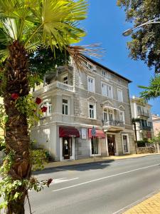 a large white building on the side of a street at Villa Sokol Apartments Opatija center in Opatija