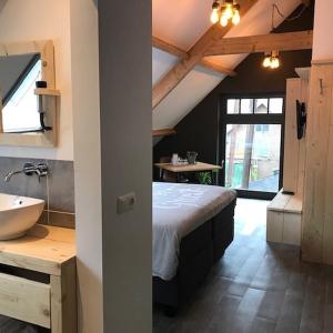 a bedroom with a bed and a sink in a room at De Hostee in Stolwijk