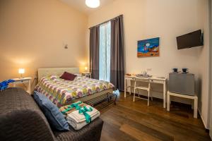 a room with two beds and a desk and a television at B&B PETER PAN in Salerno