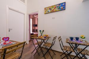 a living room with two tables and chairs and a painting on the wall at B&B PETER PAN in Salerno