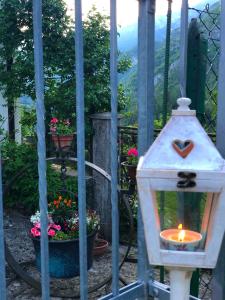 Una vela en una linterna en una puerta con flores en Le Castagne Matte, en Stenico