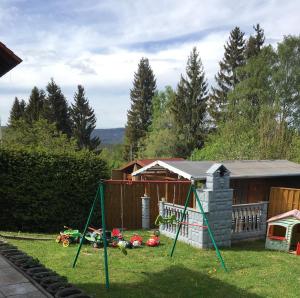 a yard with a swing set in the grass at Haus Zeichner 2 Zimmer Ferienwohnung in Feldberg