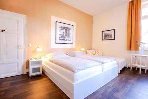ein Schlafzimmer mit einem großen weißen Bett in einem Zimmer in der Unterkunft Hajo´s Germania Lodge & Irish Pub in Rüdesheim am Rhein