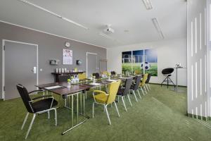 een eetkamer met een lange tafel en gele stoelen bij Tulip Inn Hotel Düsseldorf Arena in Düsseldorf