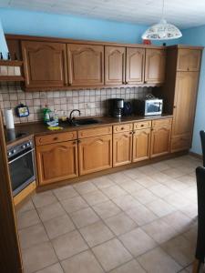 a kitchen with wooden cabinets and a sink at Ferien auf dem Land in Warstein