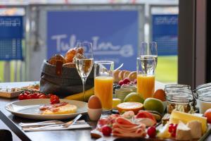 een tafel met ontbijtproducten en een glas champagne bij Tulip Inn Hotel Düsseldorf Arena in Düsseldorf