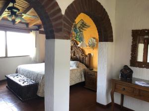 1 dormitorio con cama, mesa y espejo en Villa San Jose Hotel & Suites en Morelia