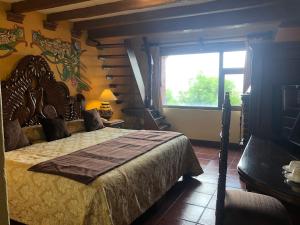 a bedroom with a large bed and a window at Villa San Jose Hotel & Suites in Morelia