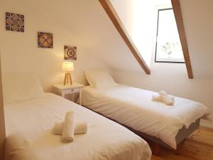 two twin beds in a room with a window at Sintra Chalet in Sintra