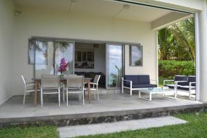 een patio met een tafel en stoelen in een huis bij Villa du Lagon in Blue Bay