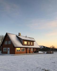 a large wooden house in a snow covered field at Rosi Puhkemaja in Koljala