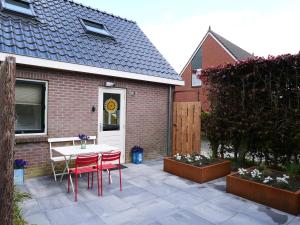 a patio with a table and chairs in front of a house at Wadnhûs in Kollum