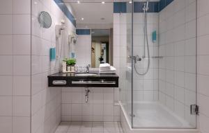 a bathroom with a shower and a sink and a tub at Tulip Inn Hotel Düsseldorf Arena in Düsseldorf