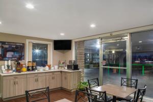 a kitchen with a table and a table and chairs at Super 8 by Wyndham Pensacola NAS Area in Pensacola