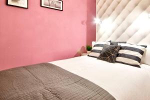 a bedroom with a large bed with pink walls at Valletta Maison d'art - Centre APT in Valletta