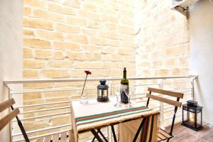 - une table avec une bouteille de vin et un vase dans l'établissement Valletta Maison d'art - Centre APT, à La Valette