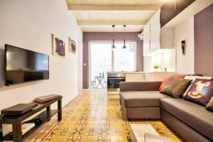 ein Wohnzimmer mit einem Sofa und einem Tisch sowie eine Küche in der Unterkunft Valletta Maison d'art - Centre APT in Valletta