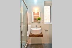 La salle de bains est pourvue d'un lavabo blanc et d'un miroir. dans l'établissement Valletta Maison d'art - Centre APT, à La Valette