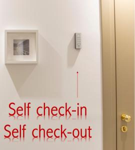 a self check in self check out sign on a door at Le Stanze del Lago Lake View in Como