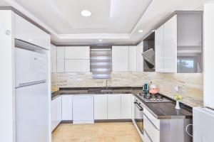 a white kitchen with white cabinets and a sink at Villa Kas Bohem in Kaş