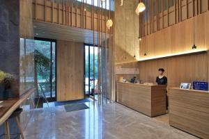 a woman standing at a counter in a lobby at EBO Hotel Hangzhou Wulin in Hangzhou