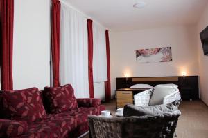 - un salon avec un canapé, une chaise et un lit dans l'établissement AdamEva Resort, à Piešťany