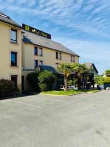 um hotel com um parque de estacionamento em frente em Atoll Hotel Logis Angers, Beaucouzé em Beaucouzé