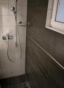 uma casa de banho com chuveiro e cabeça de chuveiro em Joline private guest apartment just feel at home 