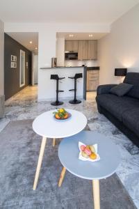 a living room with two tables and a couch at Near Croisette- 4 Star Studio -SeaView in Cannes