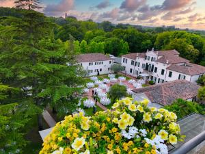 a group of white buildings with flowers in the foreground at Villa Fiorita in Monastier di Treviso
