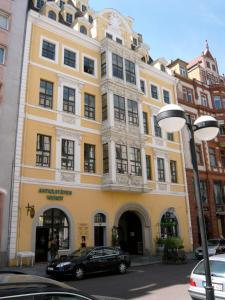 a yellow building with a car parked in front of it at Hotel Fregehaus in Leipzig