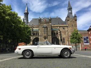 a white car parked in front of an old building at Villa Hortensie in Aachen