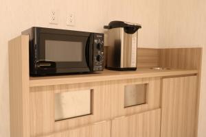 a microwave and a coffee maker sitting on a shelf at Cabin & Capsule Hotel J-SHIP Osaka Namba in Osaka