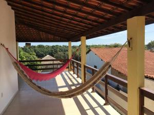 a hammock on the balcony of a house at Pousada Pura Vida in Barreirinhas
