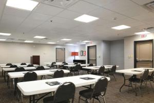 une salle de classe avec des tables et des chaises blanches dans une salle dans l'établissement Country Inn & Suites by Radisson, Oklahoma City - Bricktown, OK, à Oklahoma City