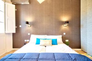 een slaapkamer met een groot bed met blauwe kussens bij Valletta Art PentHouse with seaview in Valletta