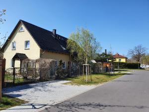 Biały dom z płotem i placem zabaw w obiekcie Ferienhaus- Dallgow w mieście Dallgow