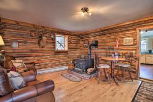 a living room with a fireplace and a table and chairs at Spacious Mtn Cabin on 7 Private Acres in Athol! in Athol