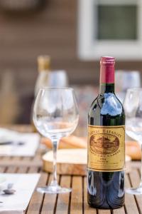 una bottiglia di vino seduta accanto a un bicchiere di vino di Les Suites d'Aliénor, Suite Jasmin a Pessac