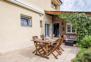 uma mesa de madeira e cadeiras num pátio em Les Suites d'Aliénor, Suite Jasmin em Pessac