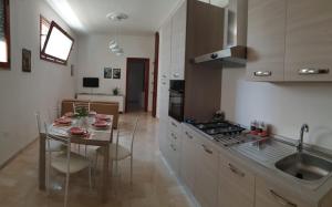 una cucina con tavolo e una sala da pranzo di Galatone -Salento-, vicino a Gallipoli, super appartamento 6 persone a Galatone
