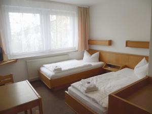 two beds in a room with two windows at Hotel Sturm in Tangermünde