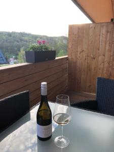 uma garrafa de vinho e um copo sobre uma mesa em Apartmán Jitka - Slunečná louka em Cerný Dul