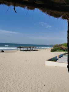 uma praia com alguns guarda-sóis e o oceano em Mandinka Lodge em Kololi