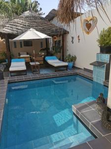 a swimming pool in a backyard with a house at Mandinka Lodge in Kololi