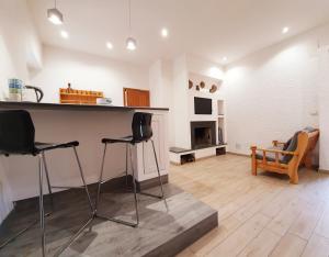- un salon avec deux tabourets de bar et une cheminée dans l'établissement Residence Serra La Nave, à Ragalna
