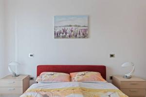 ein Schlafzimmer mit einem Bett mit zwei Nachttischen und zwei Lampen in der Unterkunft Modern and new apartment in Brianza in Vimercate