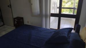 a bedroom with a blue bed and a window at Ilha dos Corais in Gamboa