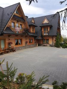 a large house with a driveway in front of it at Pokoje Małgorzatka in Zakopane